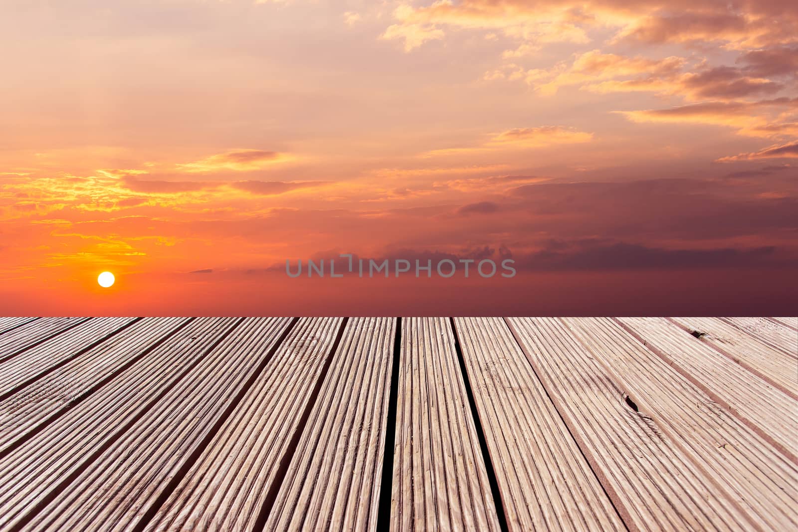 wooden table top with the colorful dramatic sky with cloud at sunset