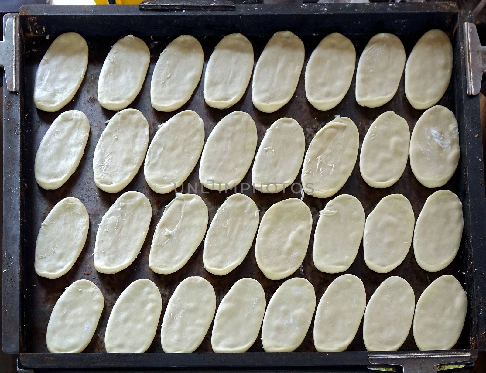 A tray with Chinese Ox Tongue biscuits is ready for baking

