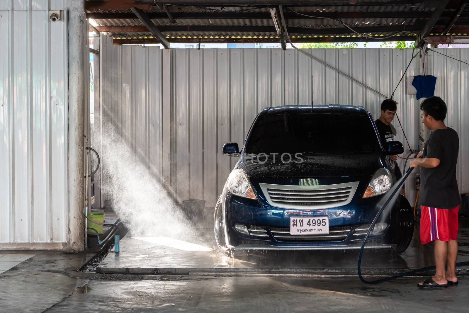 Bangkok, Thailand - February 16, 2020 : Unidentified car care staff cleaning (clean, wash, polish, wax and glass coating) the car (Car detailing) at car care shop in Bangkok Thailand