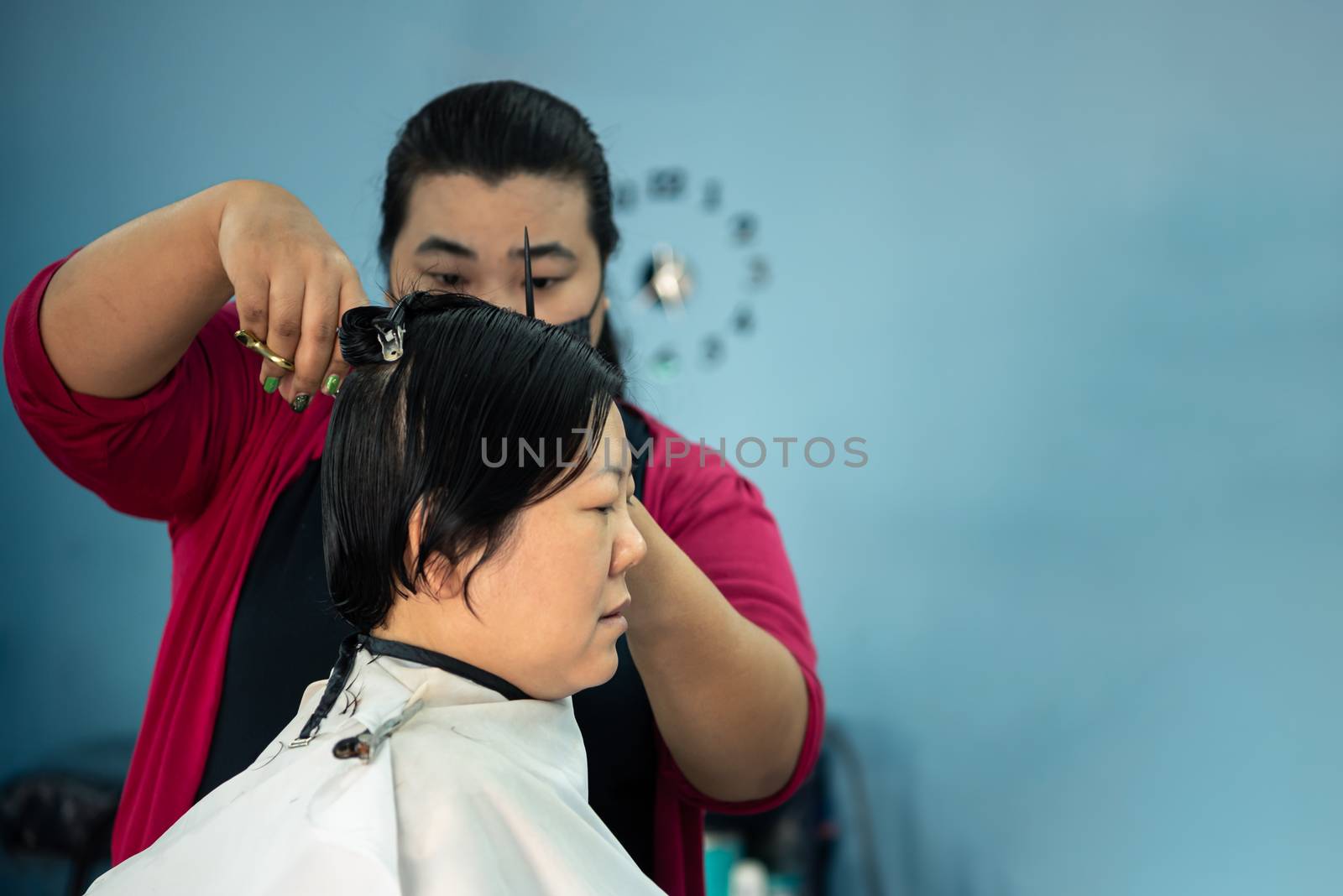 Bangkok, Thailand - February 2, 2020 : Unidentified asian woman hairdresser or hairstyle haircut a woman plump body customer in fashion hairstyle at barbershop