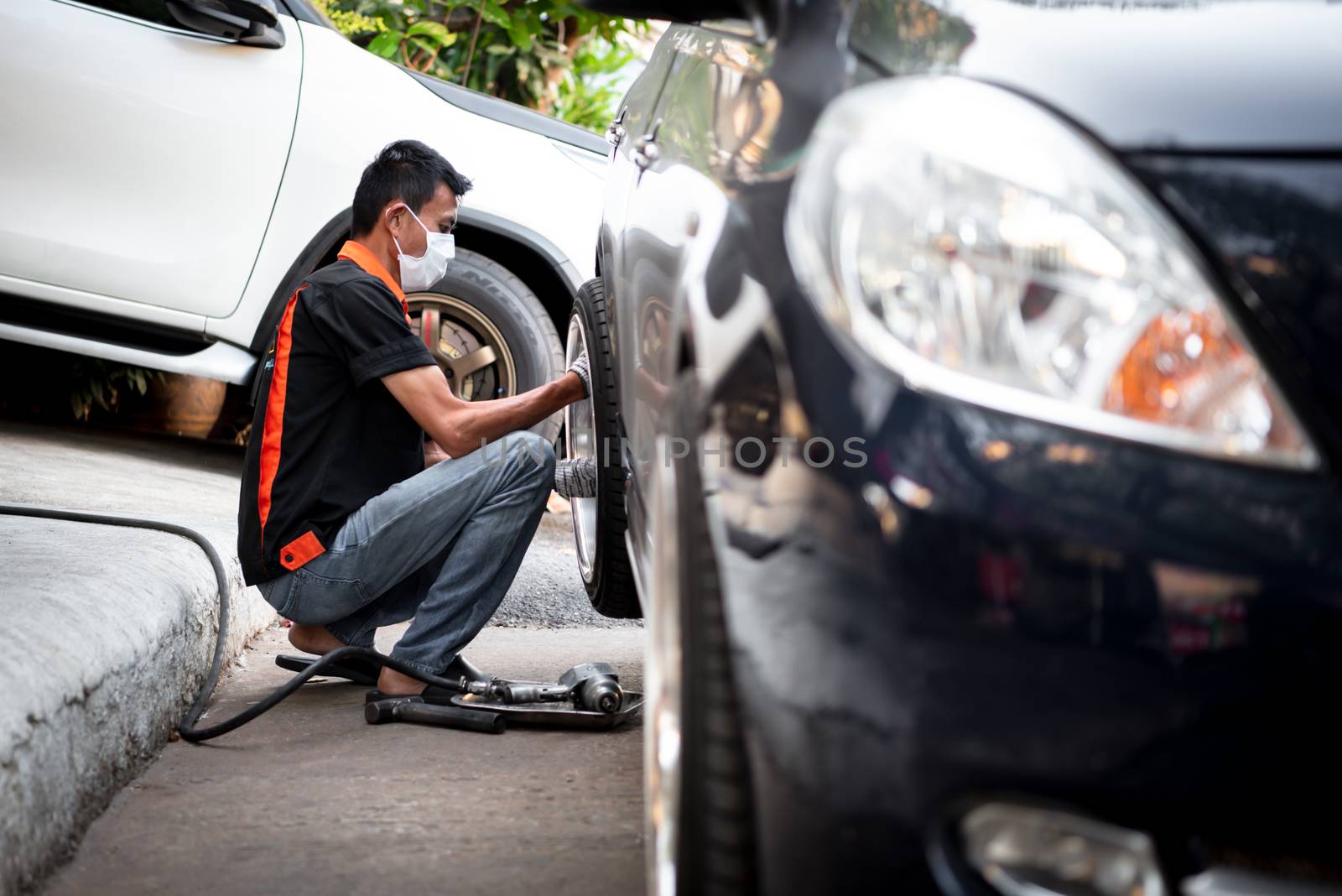 Bangkok, Thailand - February 15, 2020 : Unidentified car mechanic or serviceman disassembly and checking a disc brake and asbestos brake pads for fix and repair problem at car garage or repair shop