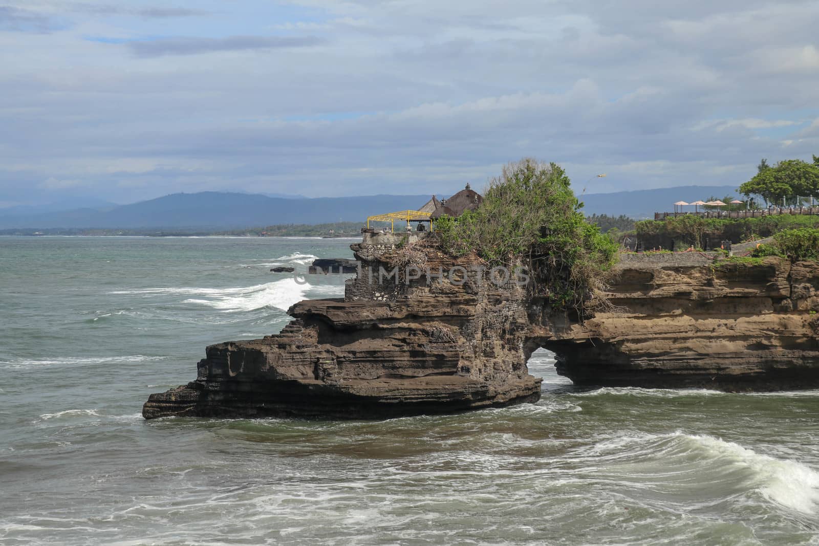 Batu Bolong beach which has an tourism attraction spot close to Tanah Lot temple. Huge hole in rock cliff below Pura Batu Bolong temple. Hindu Temple on the Beatiful Rock in the morning light, Bali.