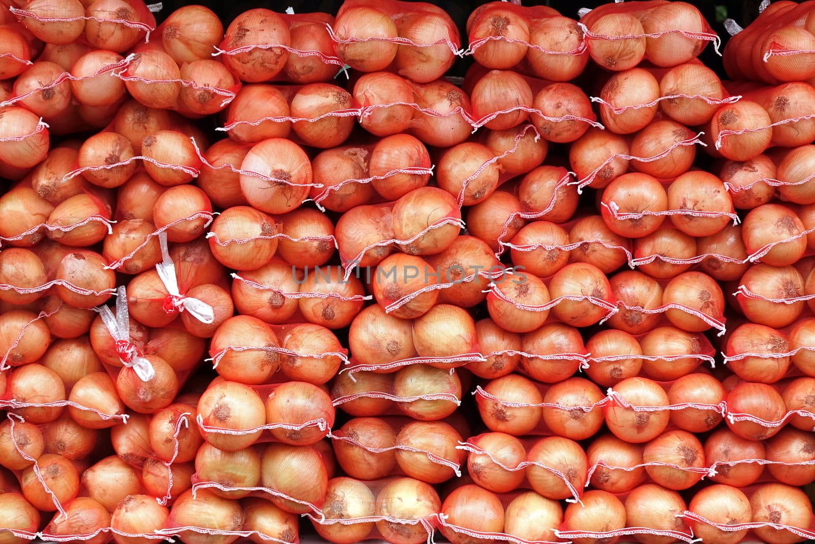 Large sacks of onions are sold at an outdoor market