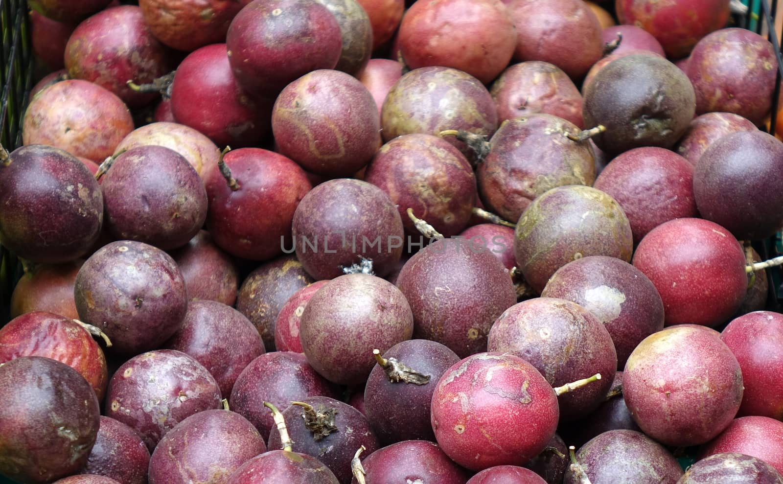 Purple passion fruits are sold at an outdoor market