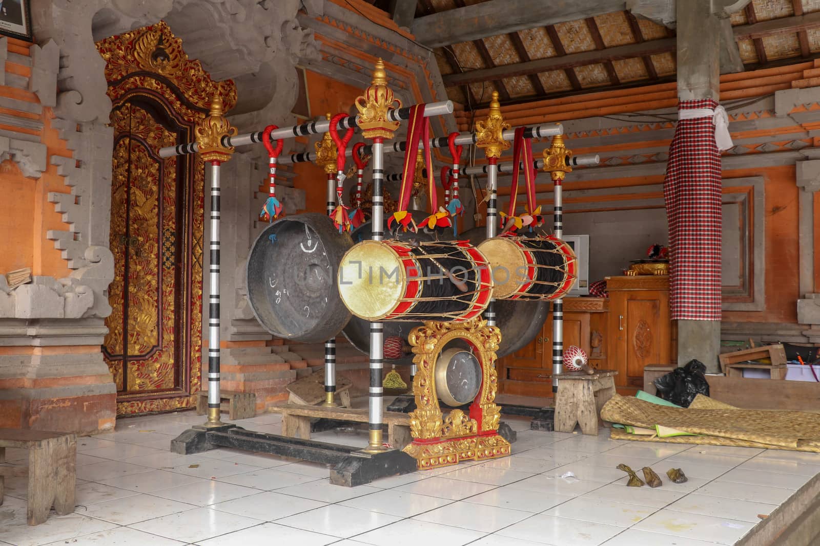 Musical instruments in a Hindu temple on Bali island, Indonesia. Drums and gongs suspended on load-bearing wooden ornate constructions. Musical instruments used in ceremonies.