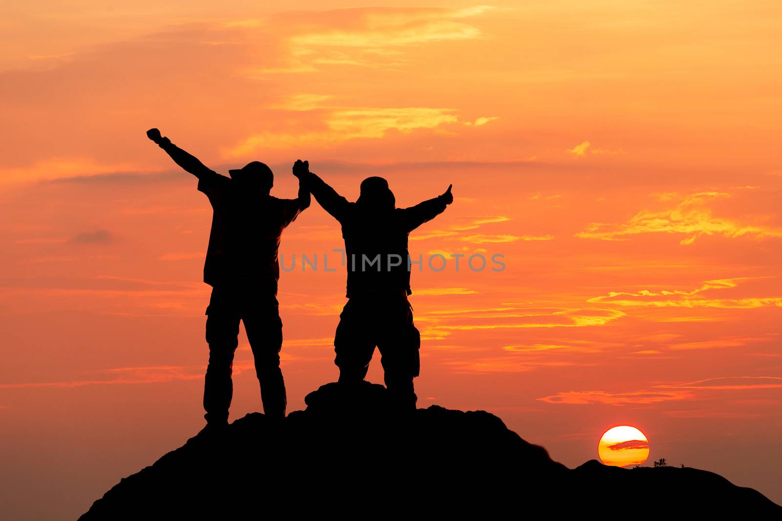 Silhouette of man hold up hands on the peak of mountain,success  by freedomnaruk