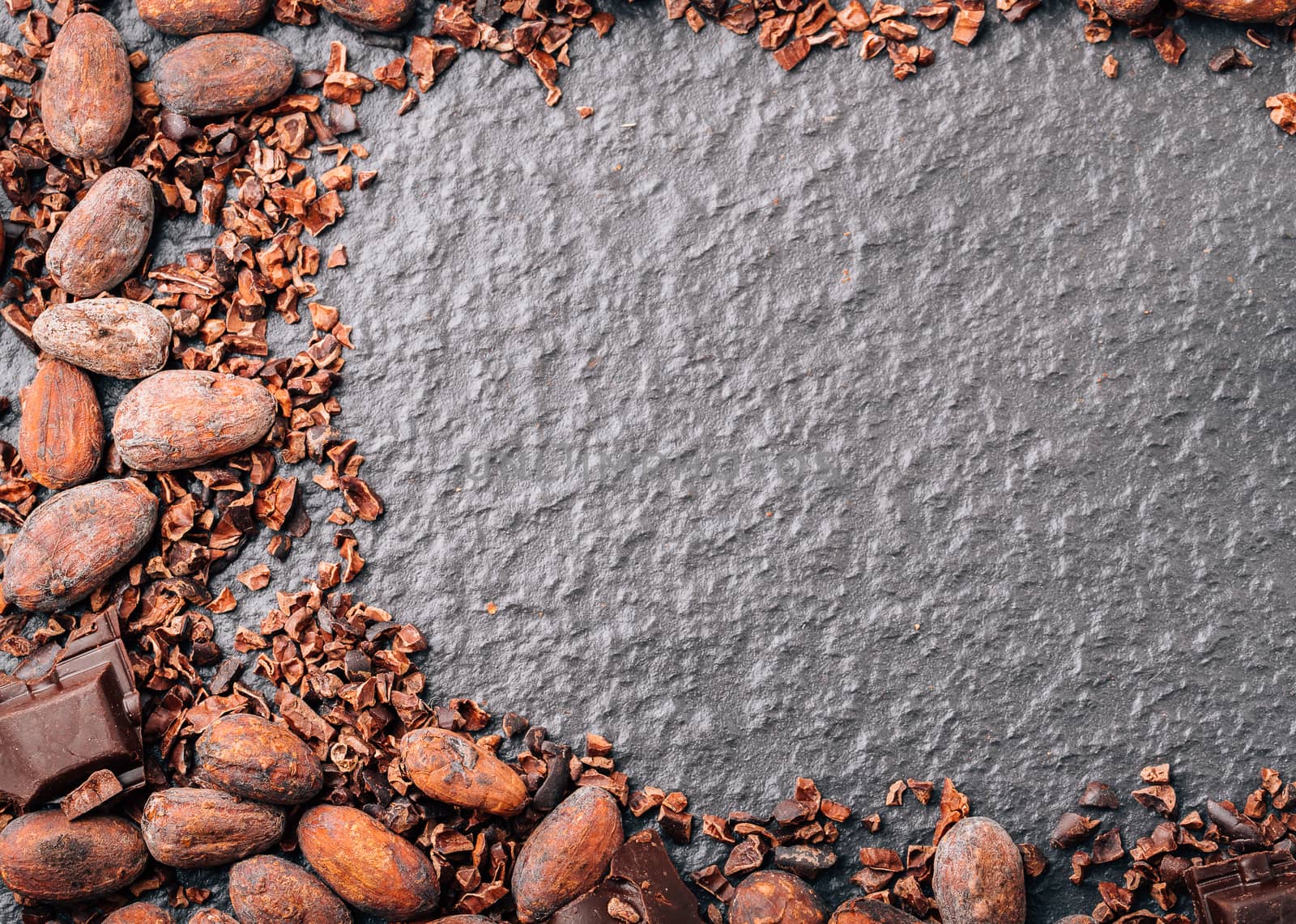 Dark chocolate pieces crushed and cocoa beans, top view