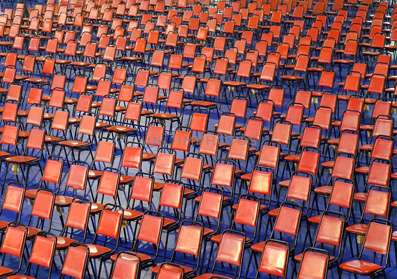Rows of red chairs are set up for a public event
