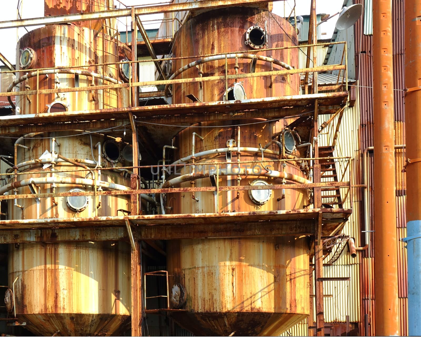 Large rusting storage tanks at a vintage industrial facility