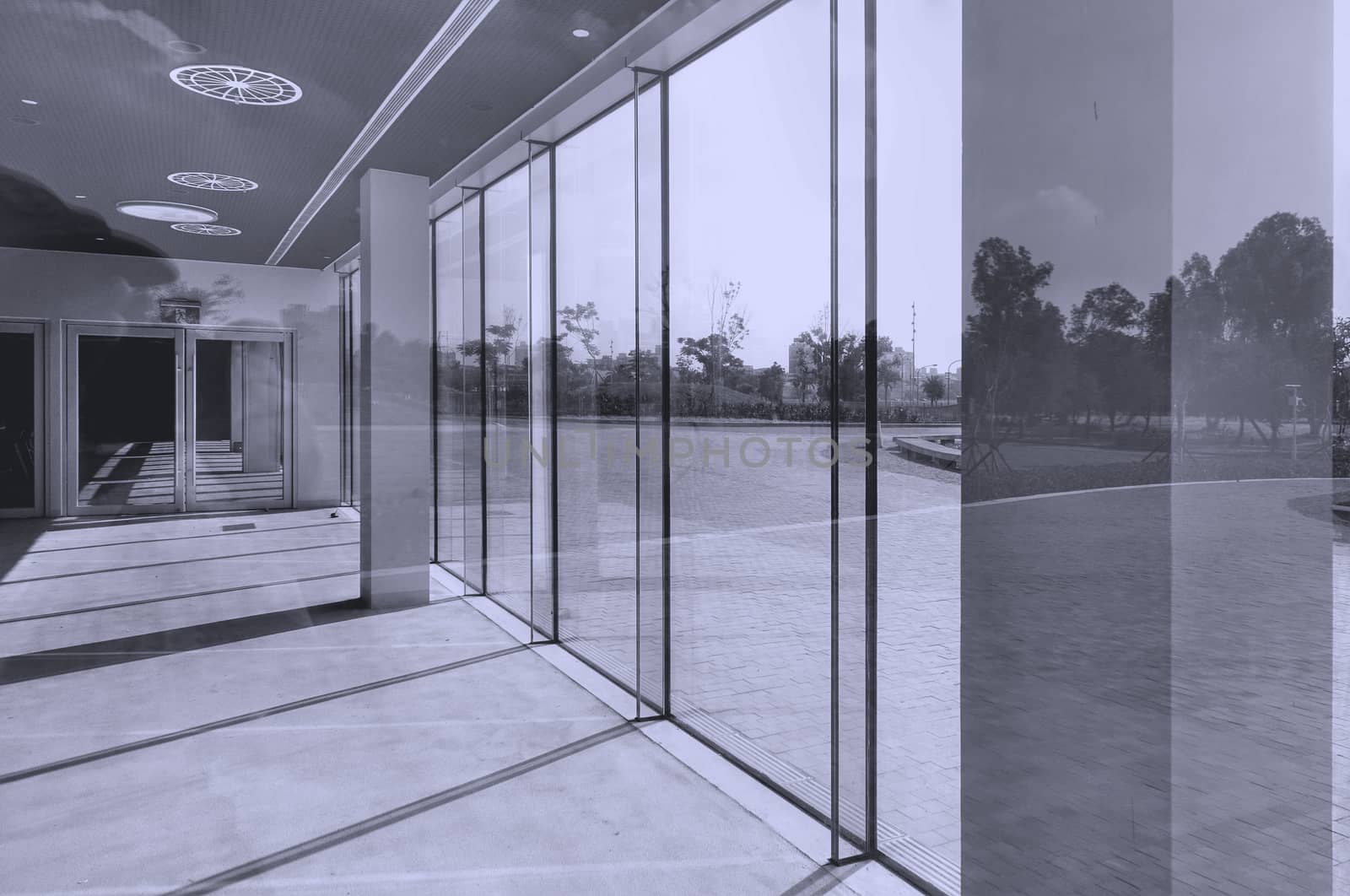 Architectural detail with glass, reflections, sunlight and shadows
