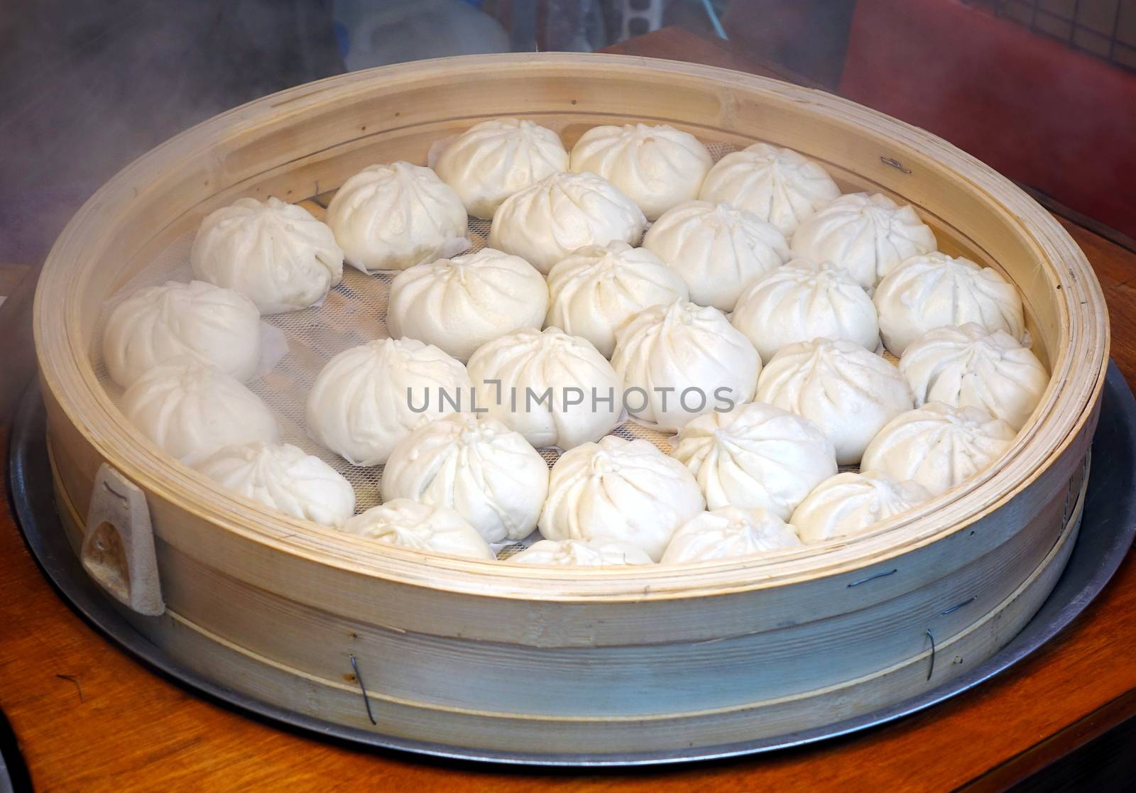 Chinese steamed buns stuffed with meat in a bamboo steamer