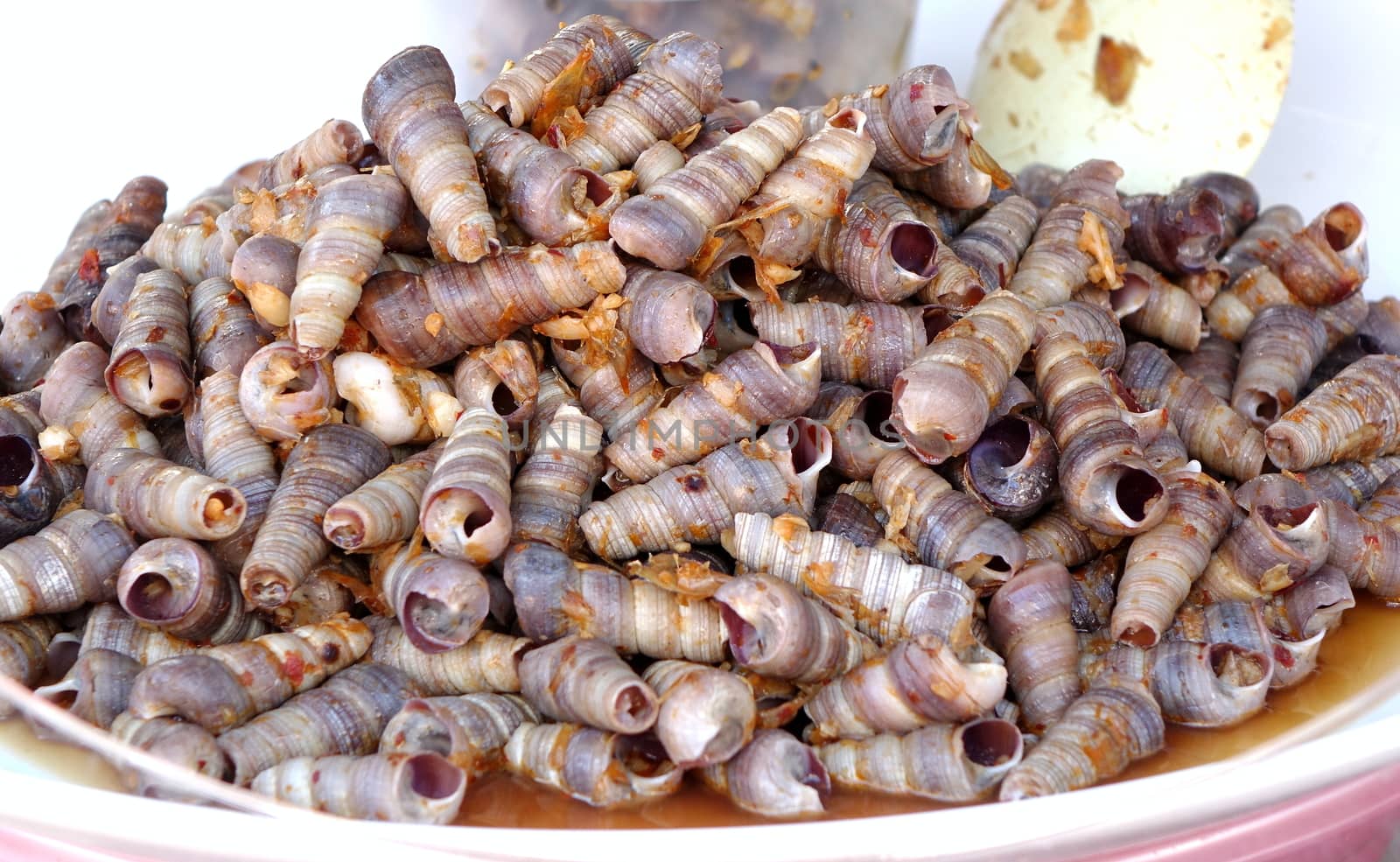 A street vendor sells boiled sea snails with red hot chili