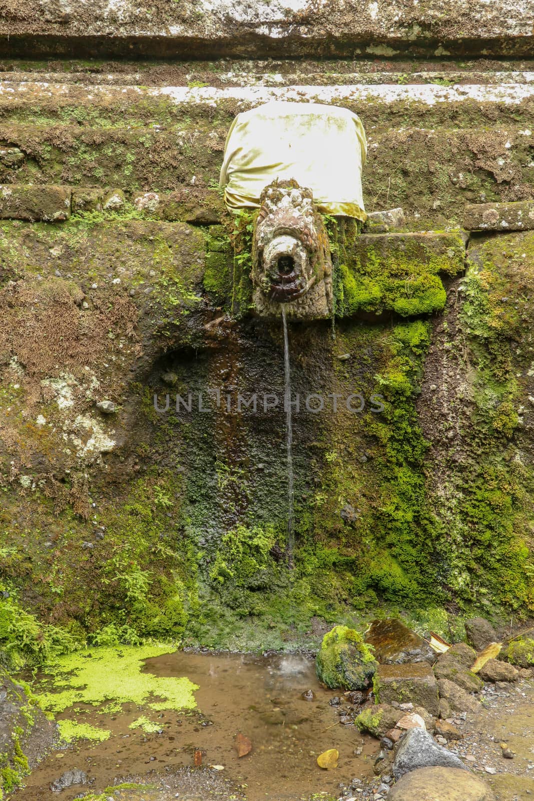Gargoyles with holy water in the complex of royal tombs of the Udayan dynasty. Ancient royal tombs at Gunung Kawi Temple. Funeral complex centered around royal tombs carved into stone cliffs, Bali.