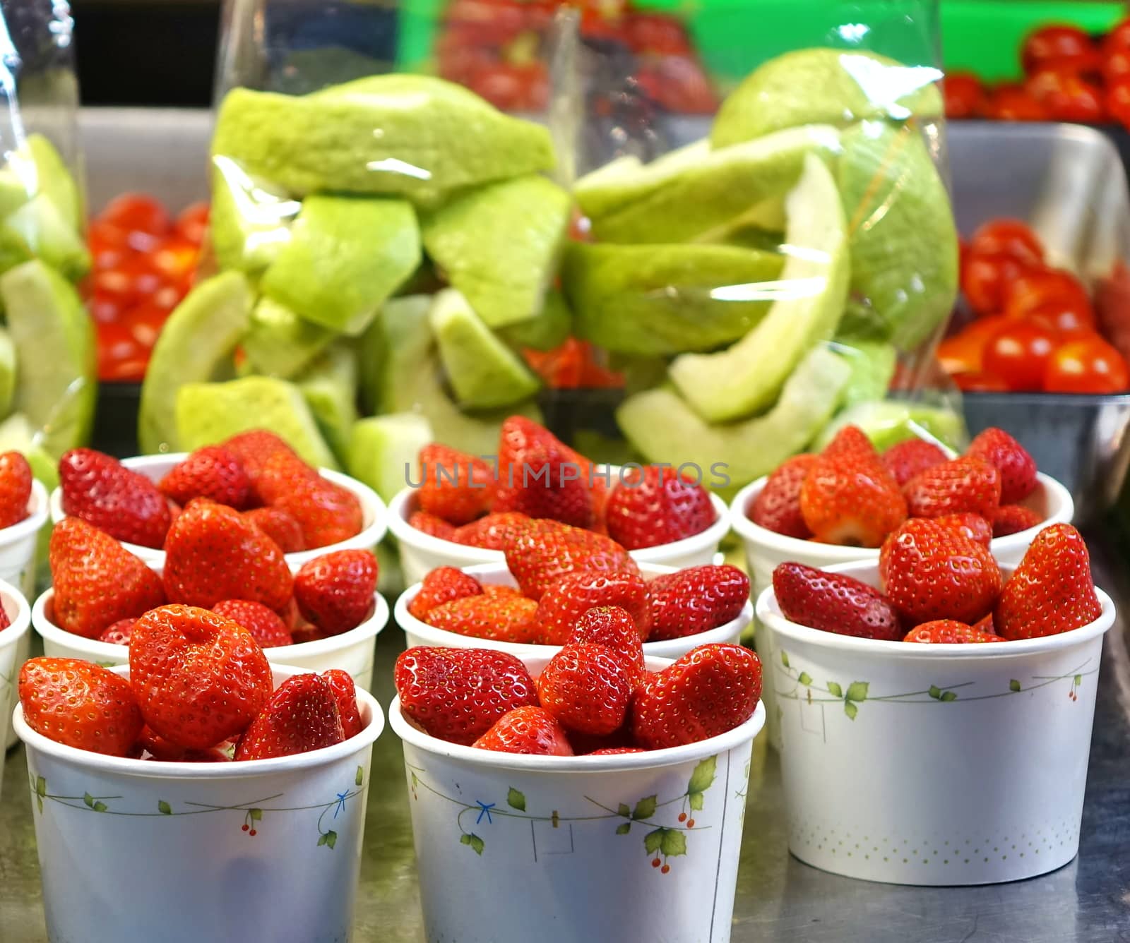 A street vendor sells strawberries and ready-to-eat guava fruits
