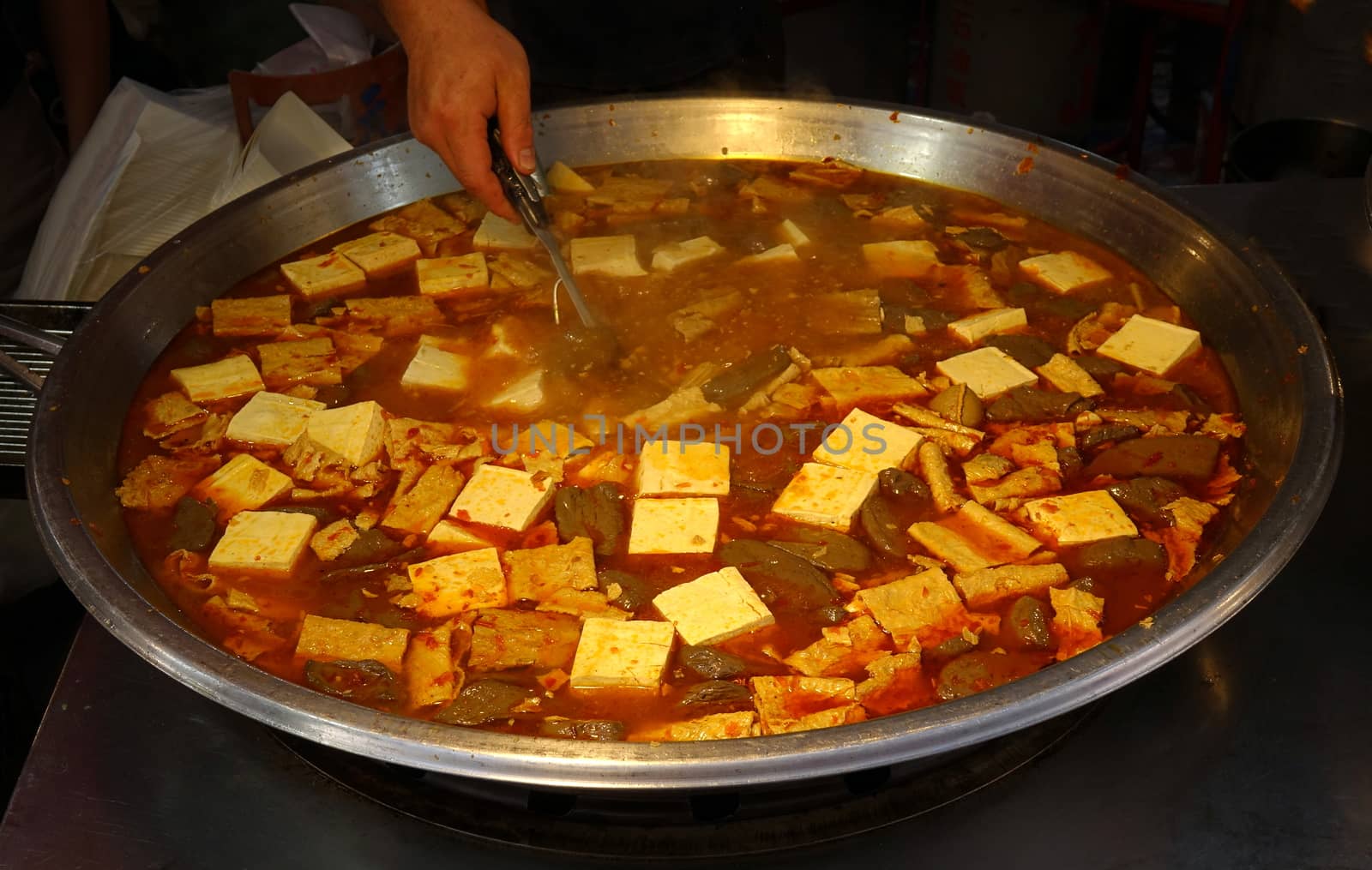 A street vendor sells a spciy stew with tofu and duck blood cakes
