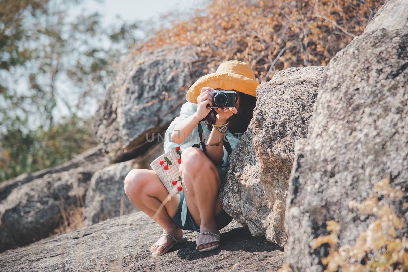 Asian pretty cute woman short jeans with hat hiking and camera in forest on mountain with cliff with happy and freedom emotion in concept travel, active lifestyle, vacation, overcome obstacles in life