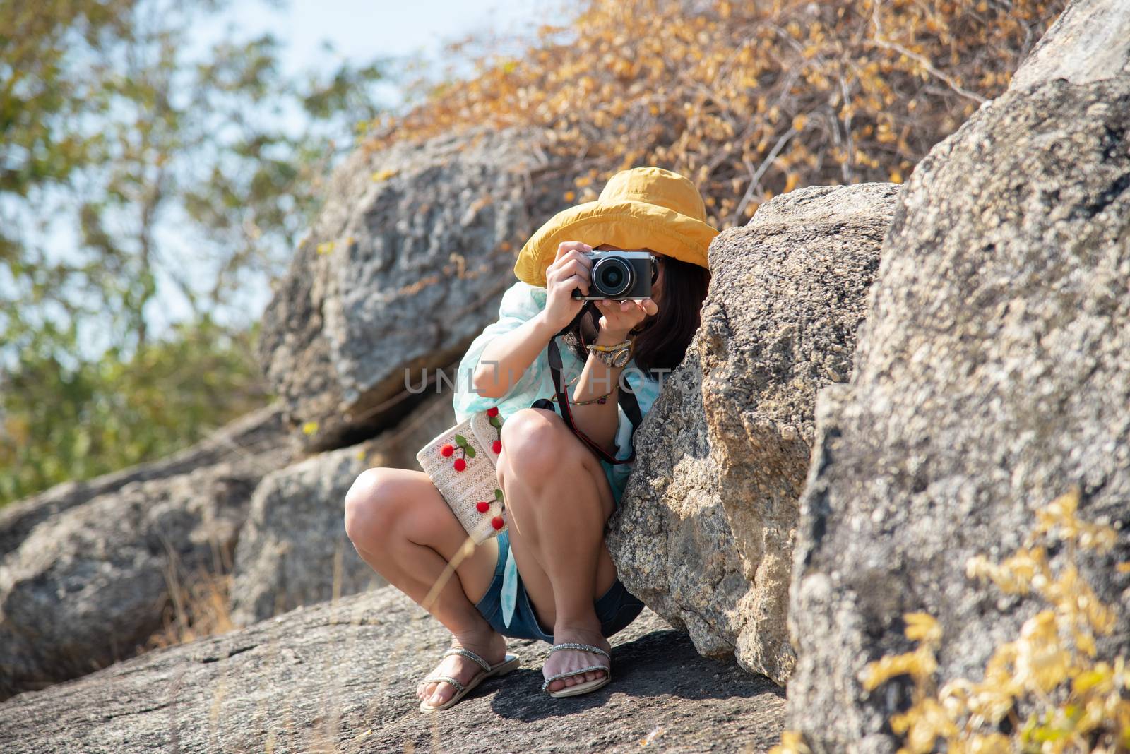 Asian pretty cute woman short jeans with hat hiking and camera in forest on mountain with cliff with happy and freedom emotion in concept travel, active lifestyle, vacation, overcome obstacles in life