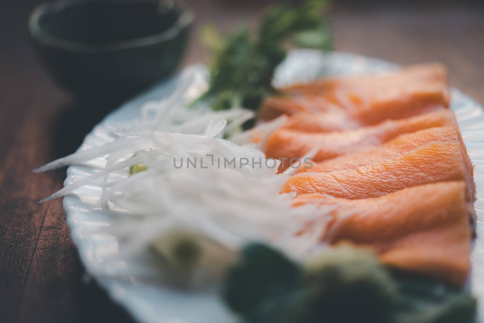 Japanese food delicacy consisting sashimi salmon of very fresh raw salmon fish sliced into thin pieces serving with radish sliced in japan restaurant