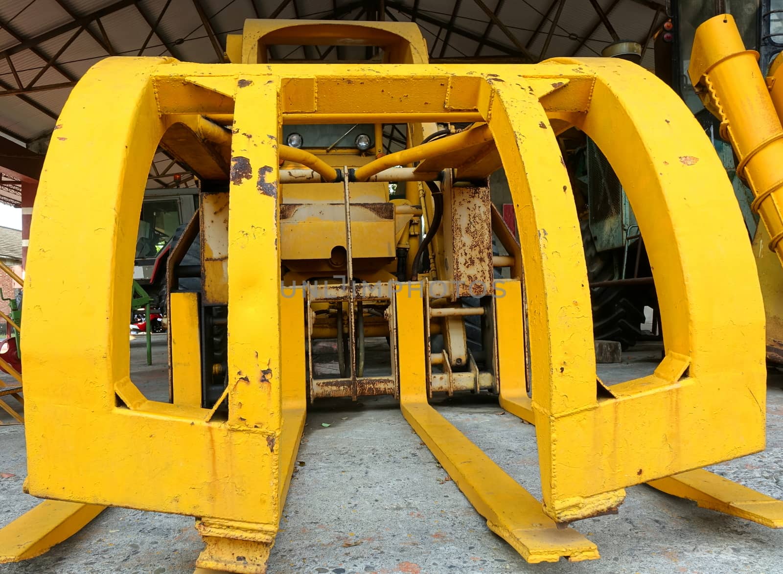 Vintage obsolete agricultural harvesting machine in bright yellow
