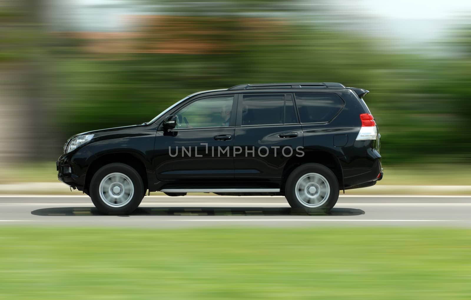 A panning shot of a speeding SUV