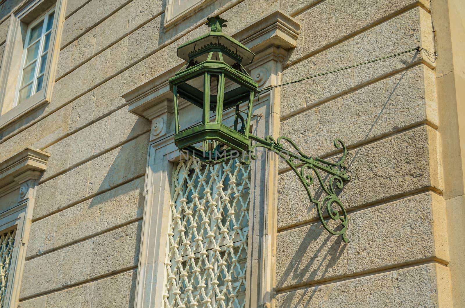 Ancient street lamp on a stone wall