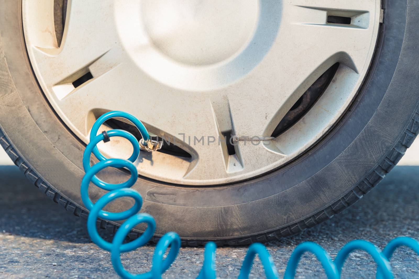 inflating the car tires with air using a compressor.