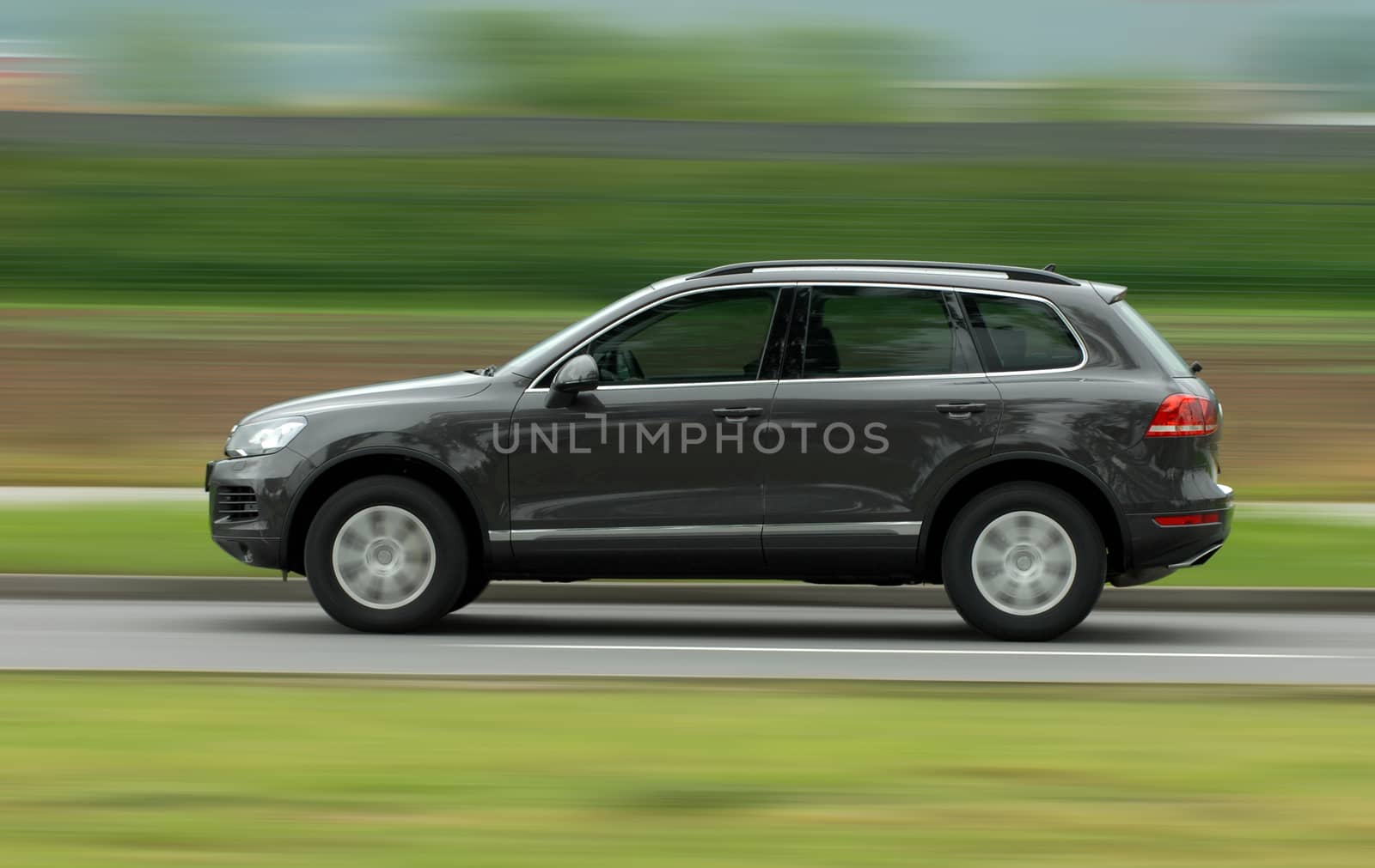 A panning shot of a speeding SUV