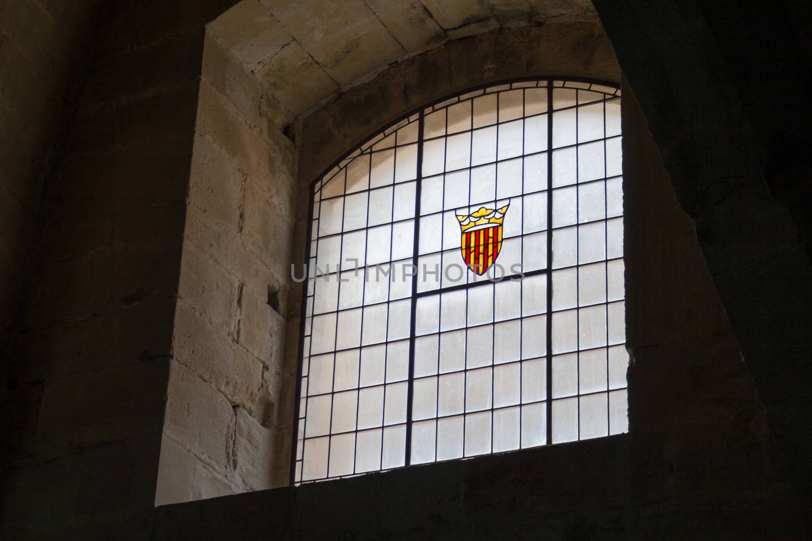old castle window in darkness with the Coat of arms of the Crown of Aragon by tanaonte