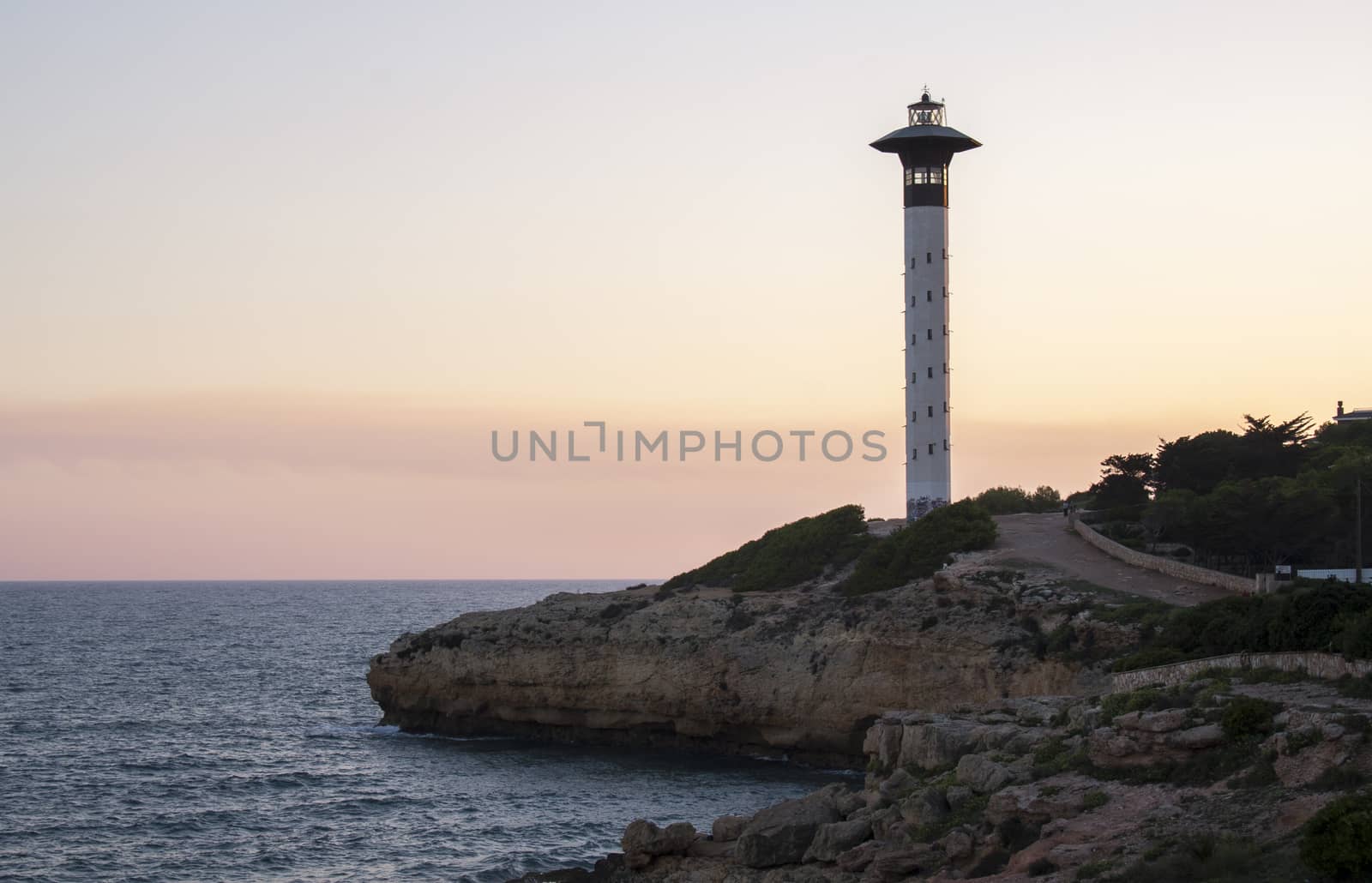 Sunset view of torredembarra's beacon, in Tarragona, Spain by tanaonte