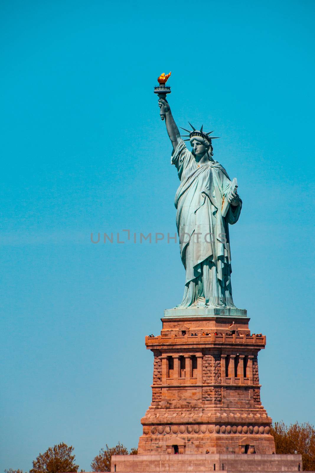 Teal and orange view of the statue of Liberty in New York City by tanaonte