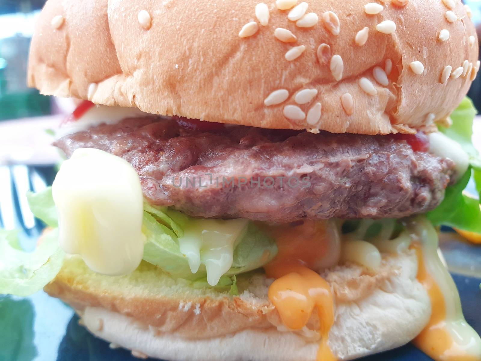 Hamburger is a fast food make from bun, meat, cheese and vegetable  in fastfood restaurant, unhealthy food or fat concept