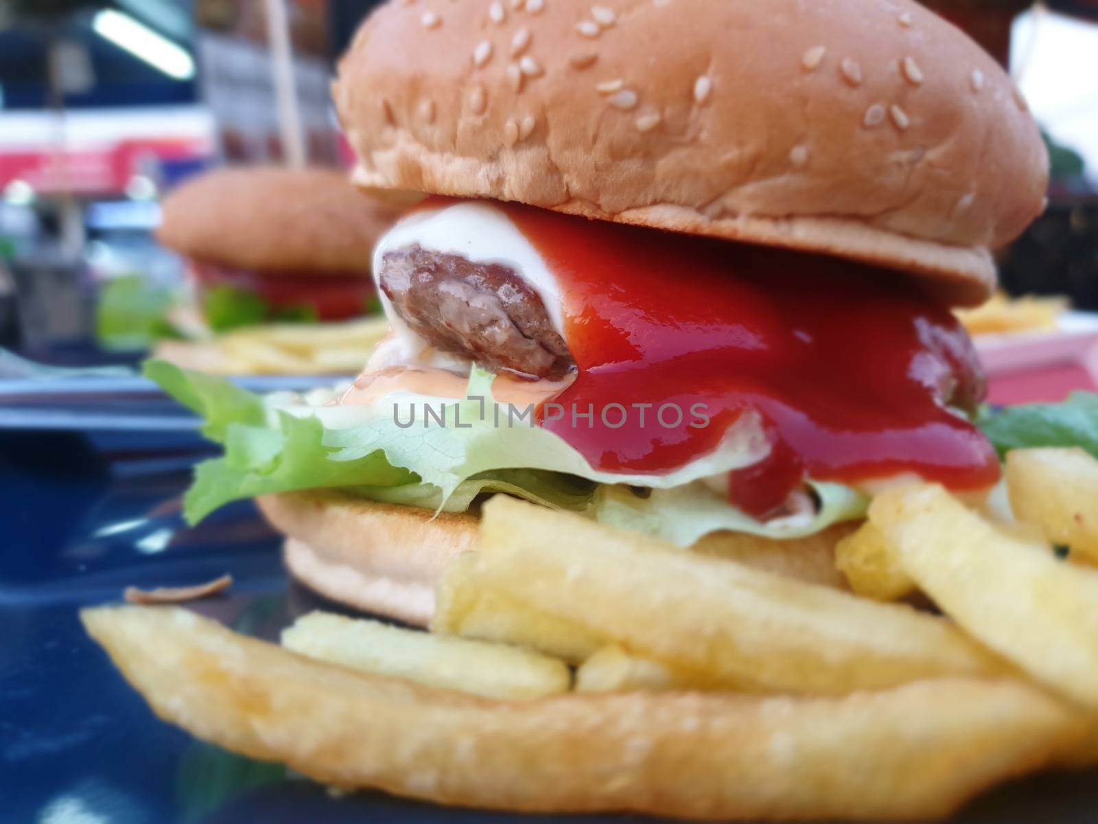 Hamburger is a fast food make from bun, meat, cheese and vegetable  in fastfood restaurant, unhealthy food or fat concept