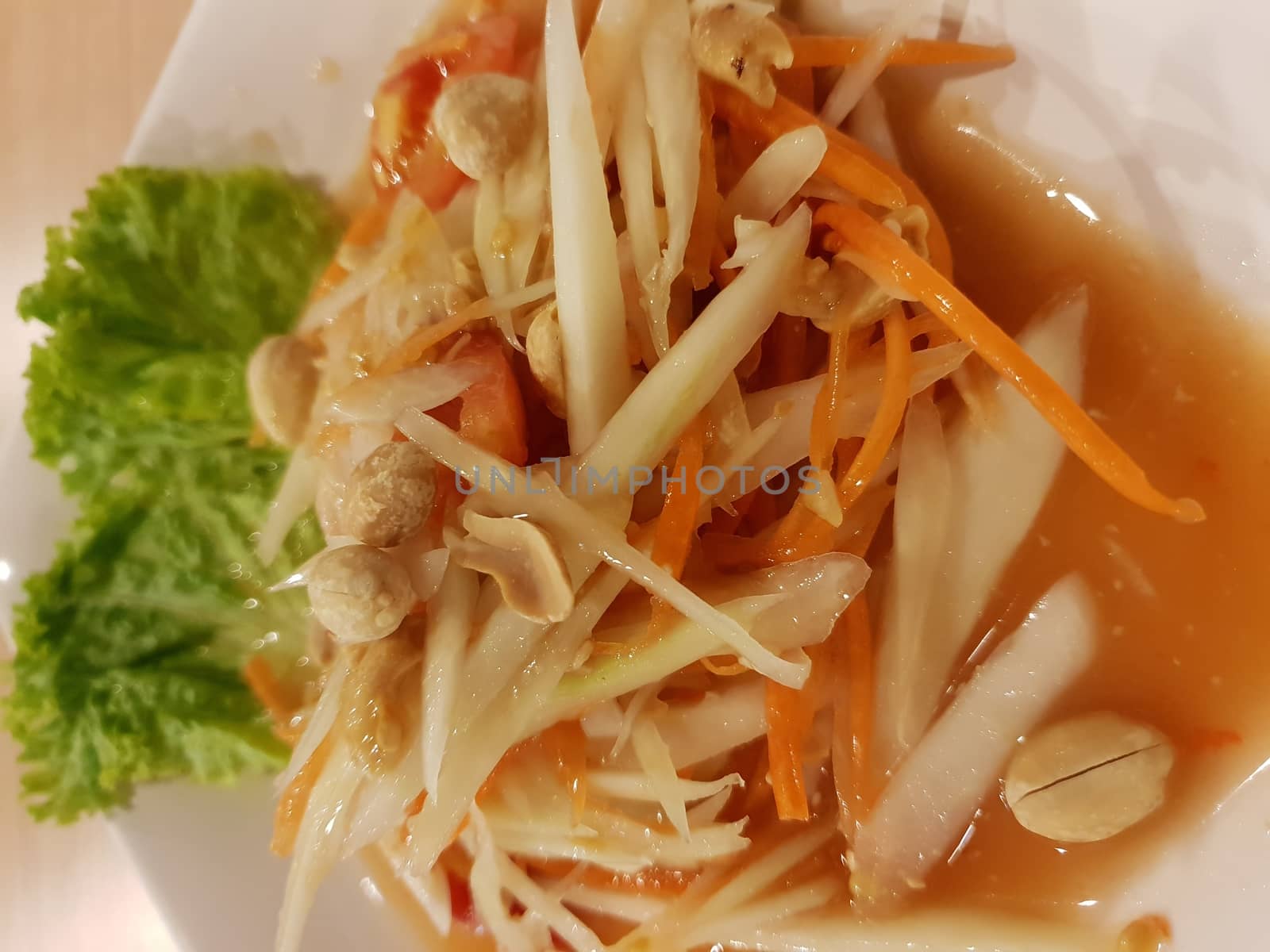 Papaya salad or Papaya Pok Pok (Som tum) for sale at Thai street food market or restaurant in Thailand