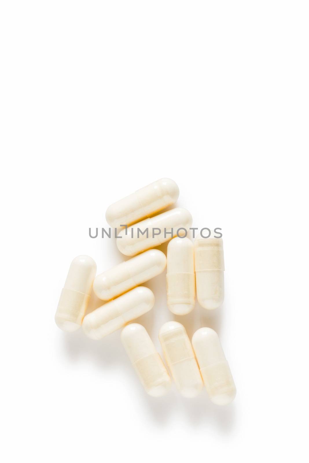 Ten yoghurt capsules isolated on a white background. Yoghurt Capsules aid in maintaining a normal healthy gastrointestinal system and digestive function.