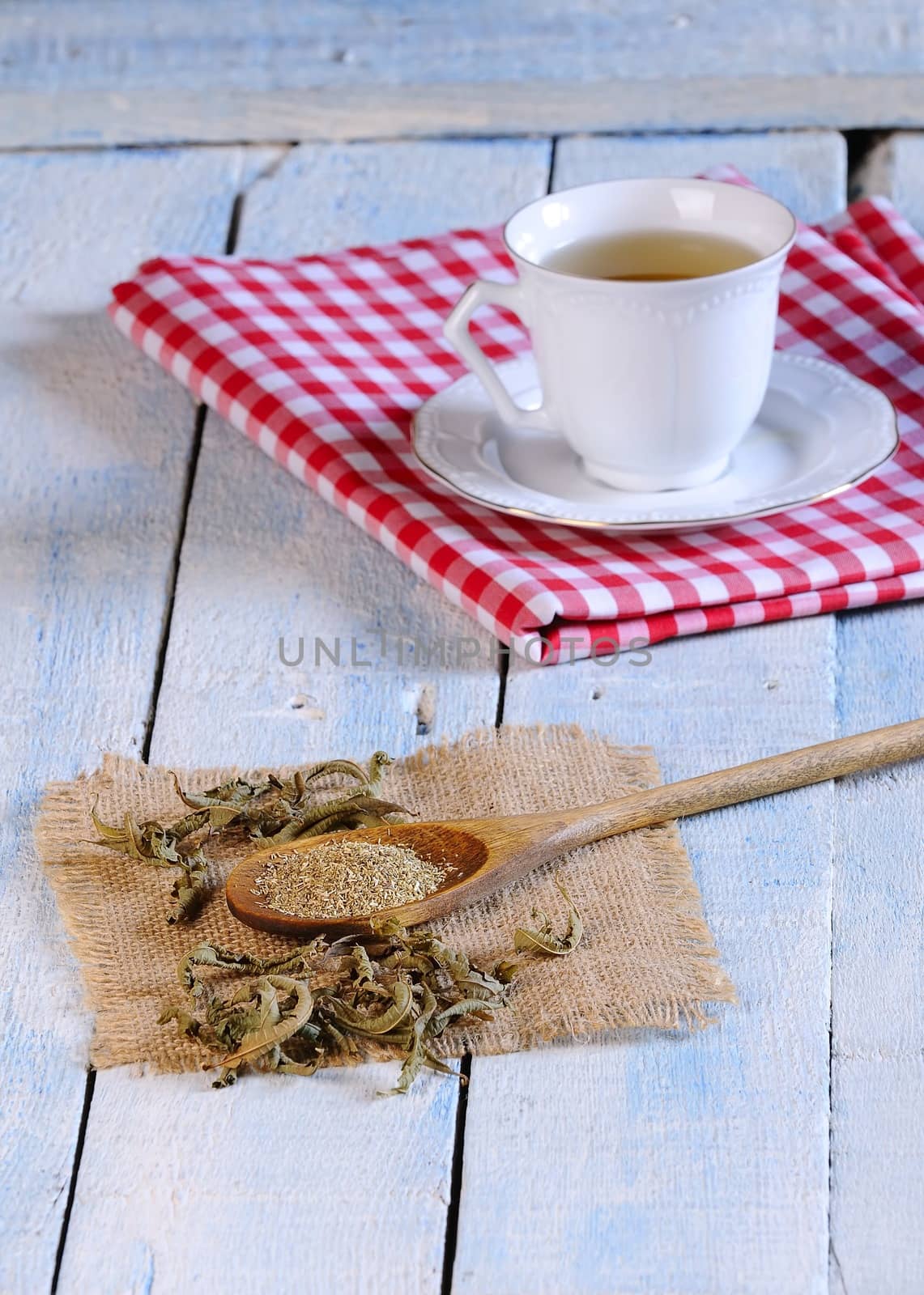 Cup of chamomile and herbs on wooden table in the kitchen.