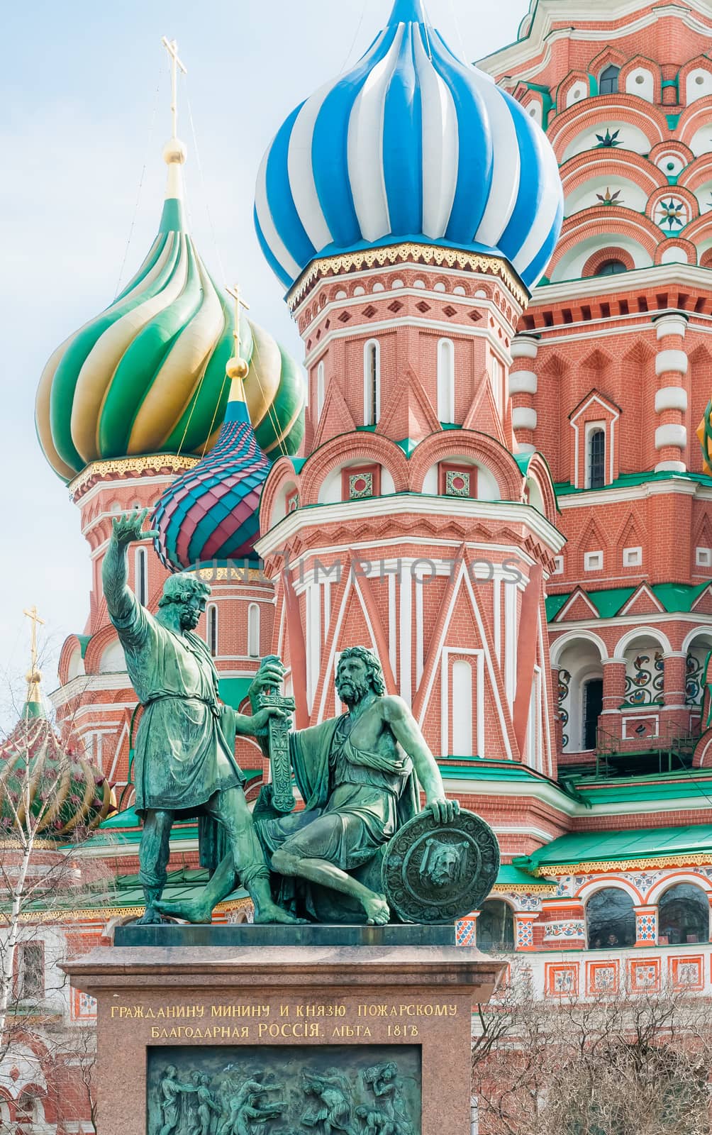 Monument to Minin and Pozharsky with the words: “To Citizen Minin and Prince Pozharsky from grateful Russia”. In background some of the colored steeples ot Saint Basil's Cathedral in Moscow, Russia
