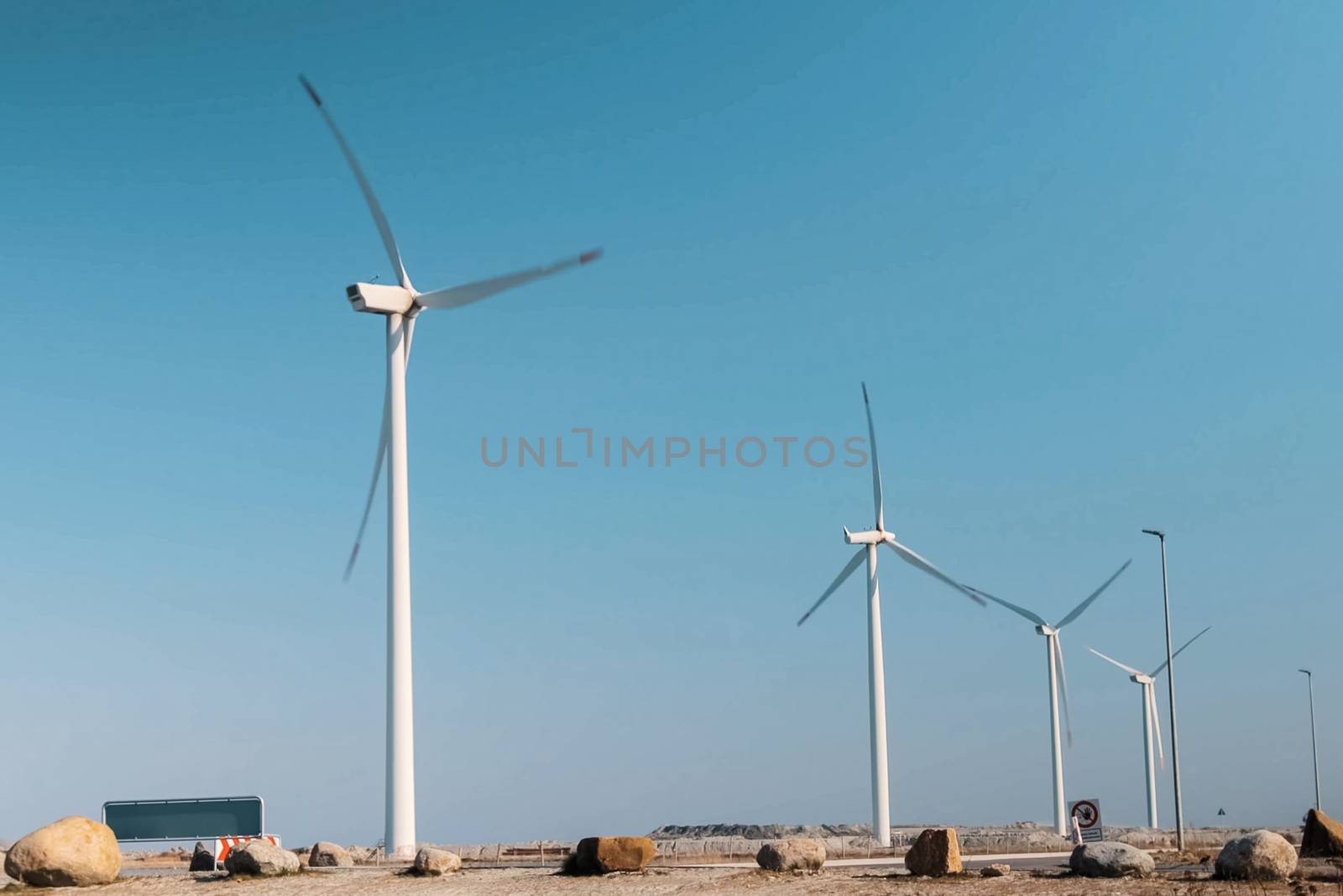 Wind farms in the countryside against a blue sky.