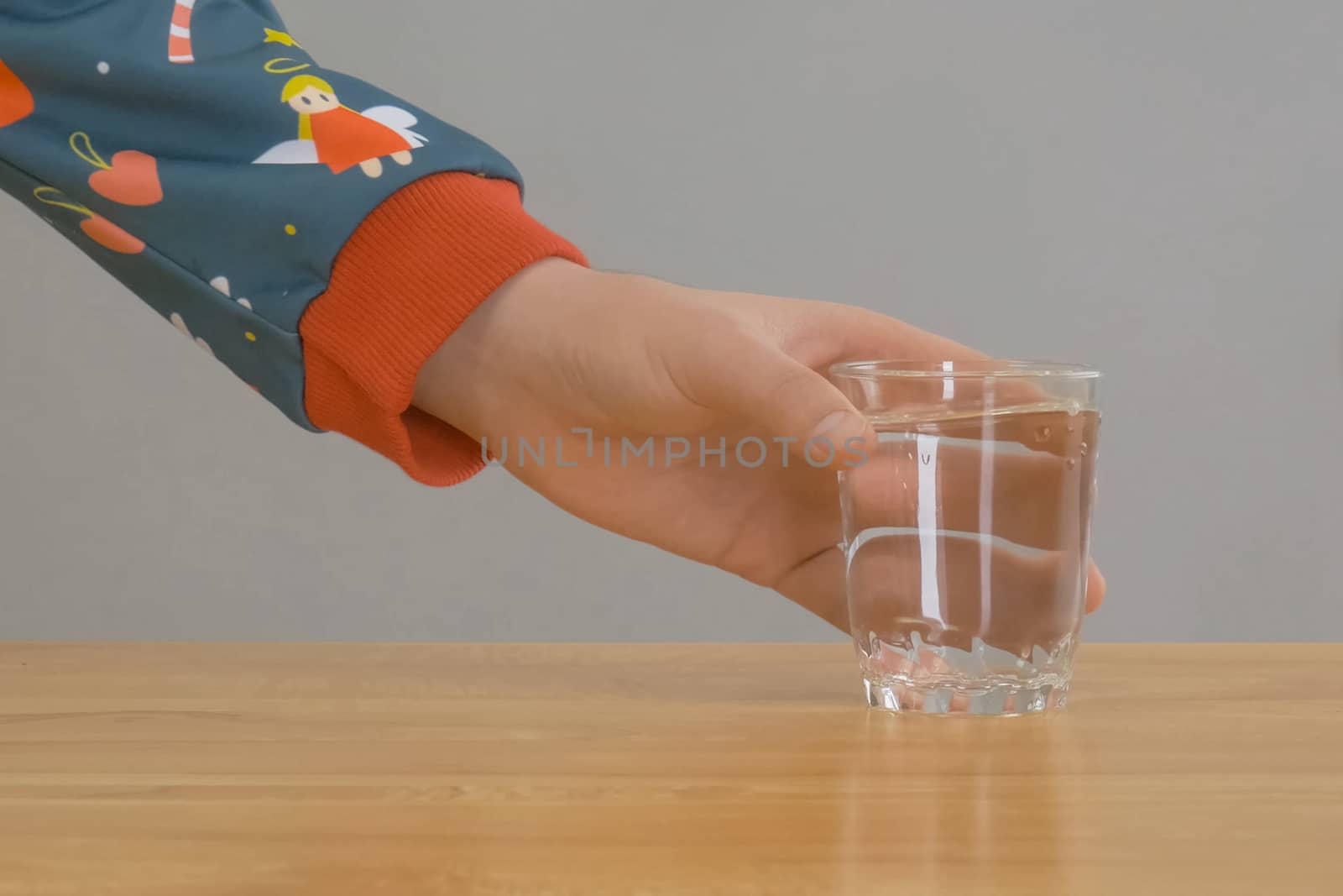 hand takes a glass of water from the table. by DePo