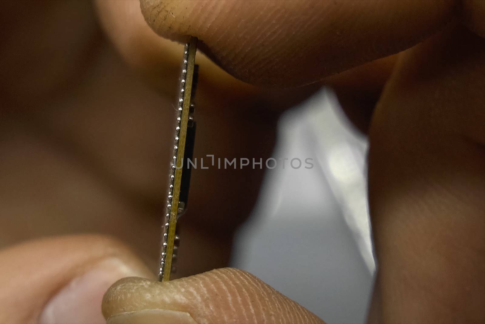 recovered computer microprocessor chip is in the hands of a man. by DePo