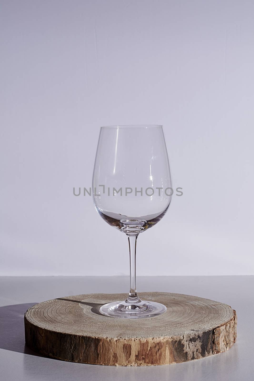 Glass of wine on white background, high key, wooden stump