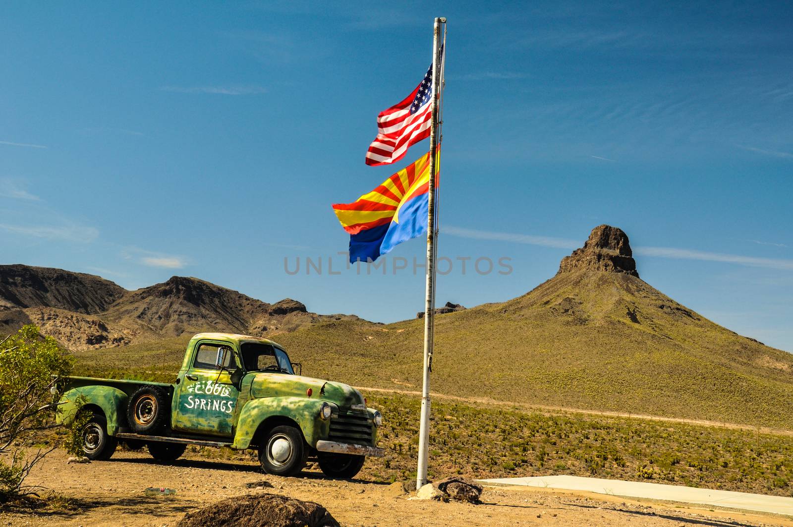 COOL SPRINGS, ARIZONA, USA - MAY 14, 2013: A vintage car in the Mojave desert on historic route 66 with national and state flags.