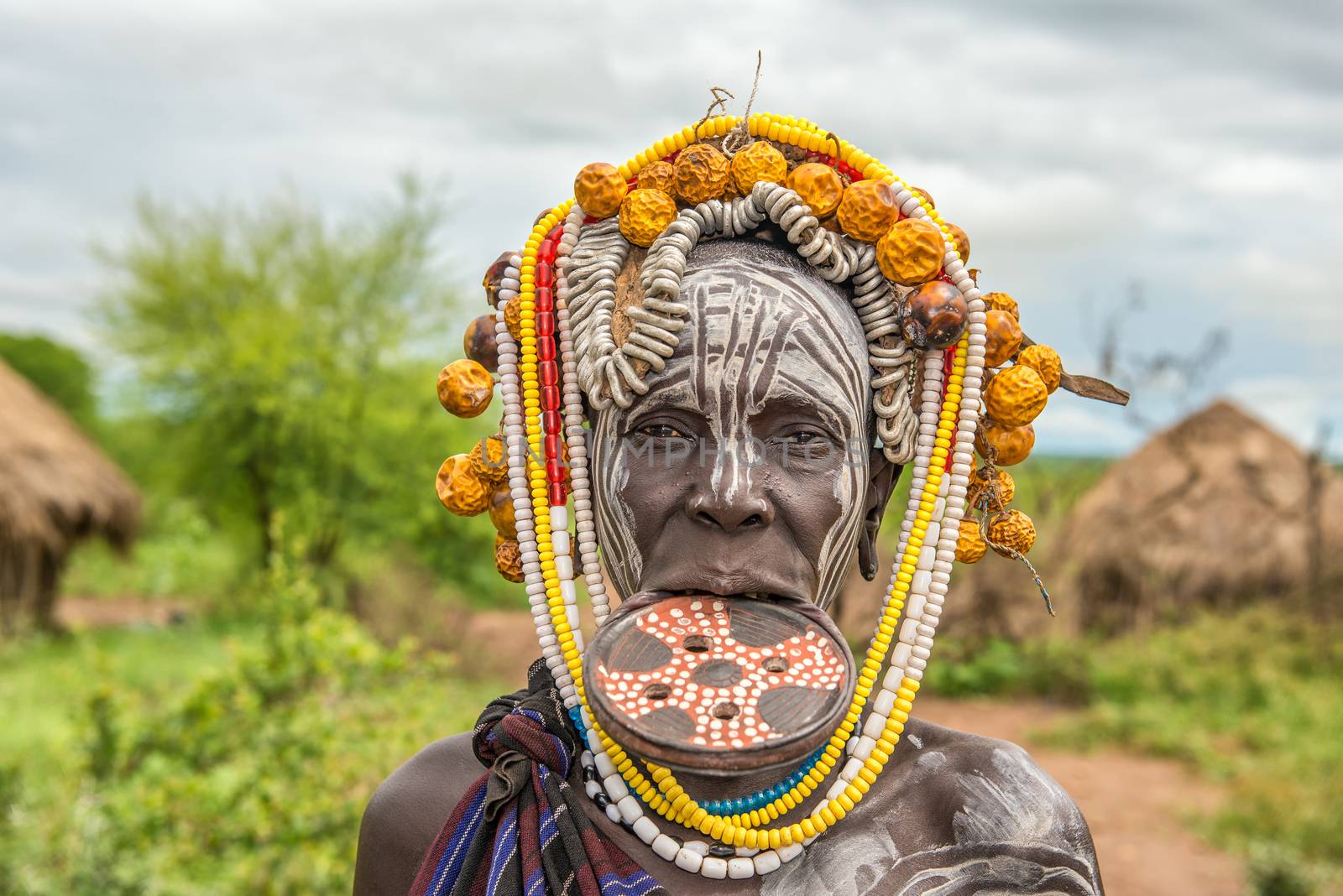 Woman from the african tribe Mursi in her village by nickfox