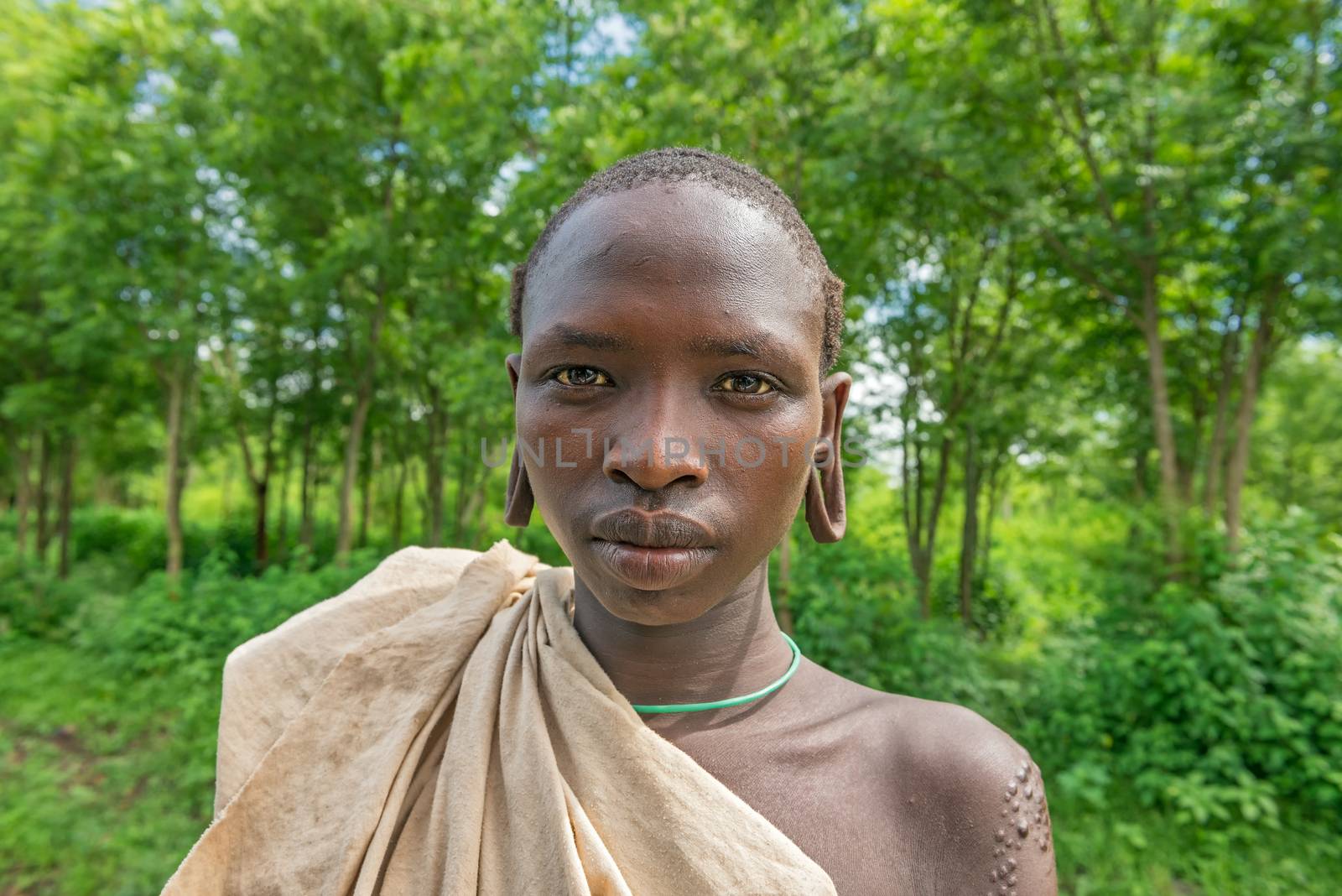 SOUTHWESTERN ETHIOPIA - MAY 3, 2015 : Portrait of a young boy from the african tribe Suri with traditionally enlarged Ears