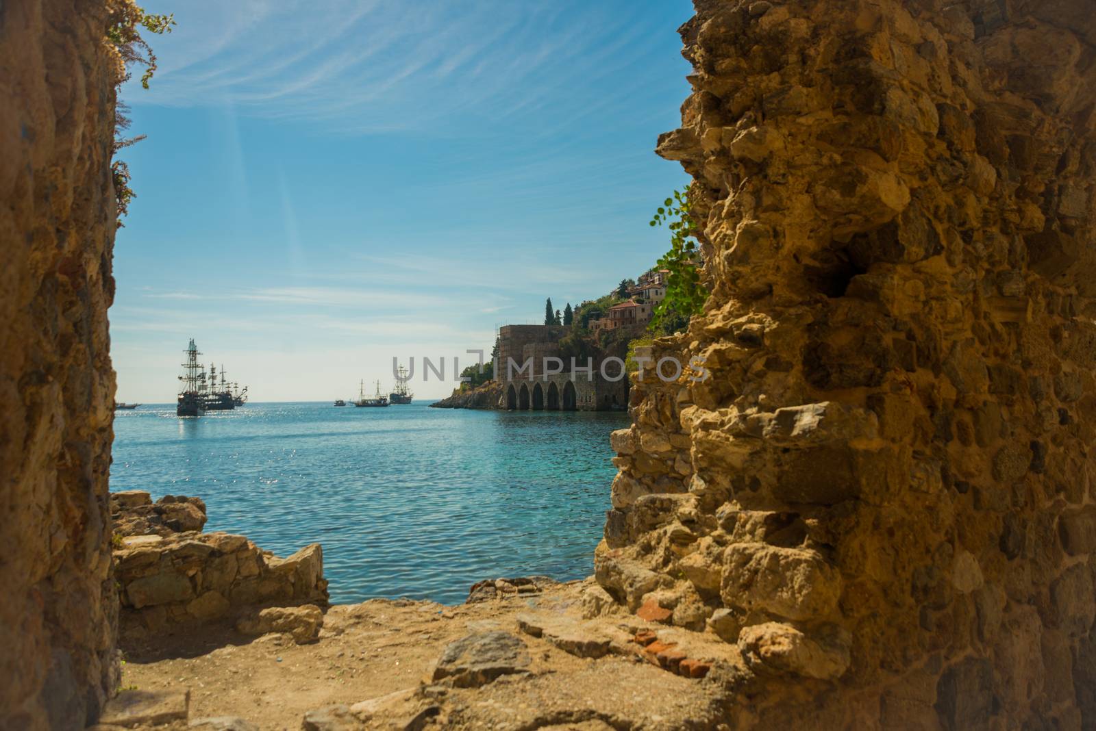 Shipyard Tersane, Alanya historical dockyard. The building with arches on the inside. Ships sailing on the sea. Alanya peninsula, Antalya district, Turkey, Asia