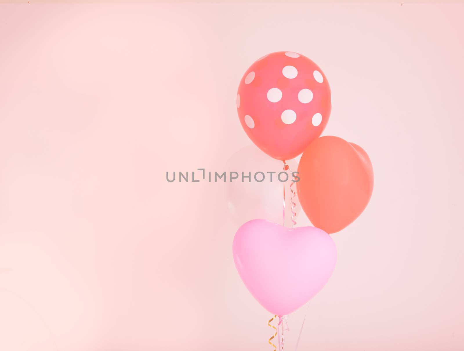 Fastive heart shape balloons on pink wall with vintage filter effect