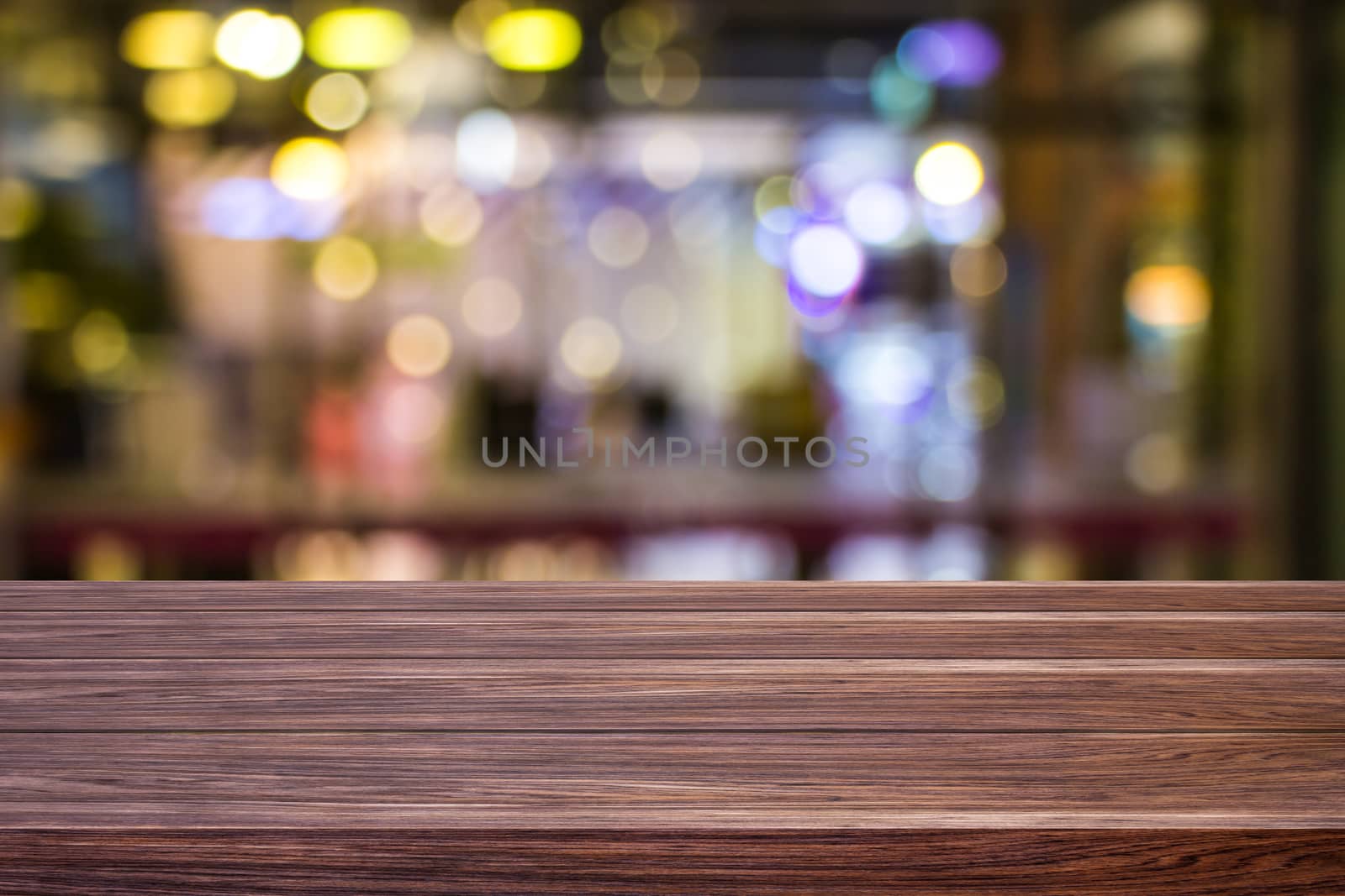 Blur cafe restaurant or coffee shop empty of dark wood table with blurred light gold bokeh abstract background for montage product display or design. by prapstock