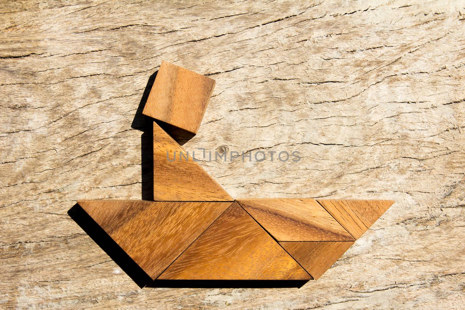 Wooden tangram puzzle as man thinking on boat shape