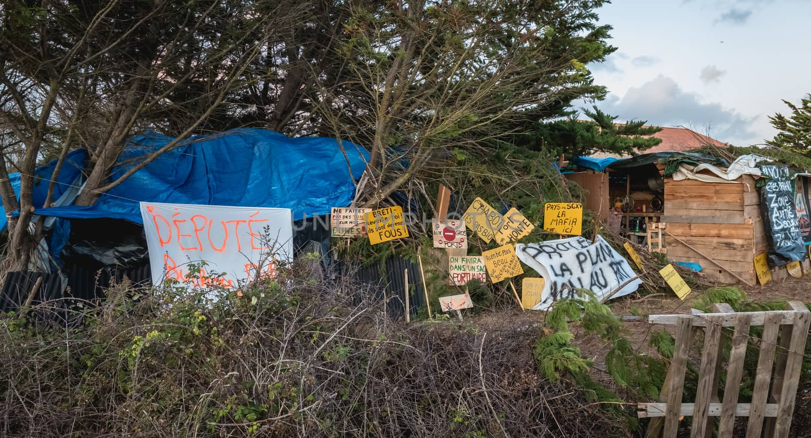 Bretignolles sur Mer, France - October 9, 2019: Set of yellow sign on a protest zone in an area to defend ZAD (Acronym of Zone to Defend) against the construction of the boat harbor