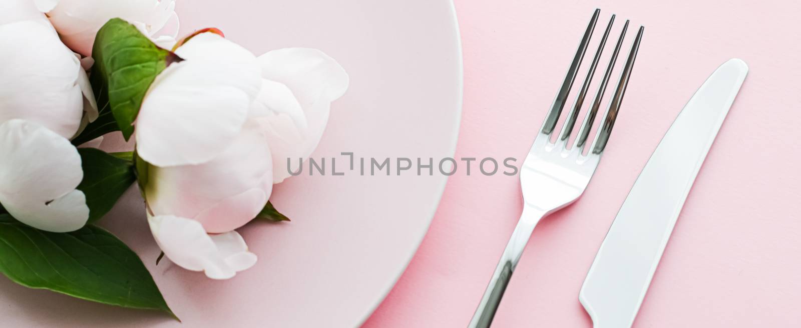 Dining plate and cutlery with peony flowers as wedding decor set on pink background, top tableware for event decoration and menu branding by Anneleven