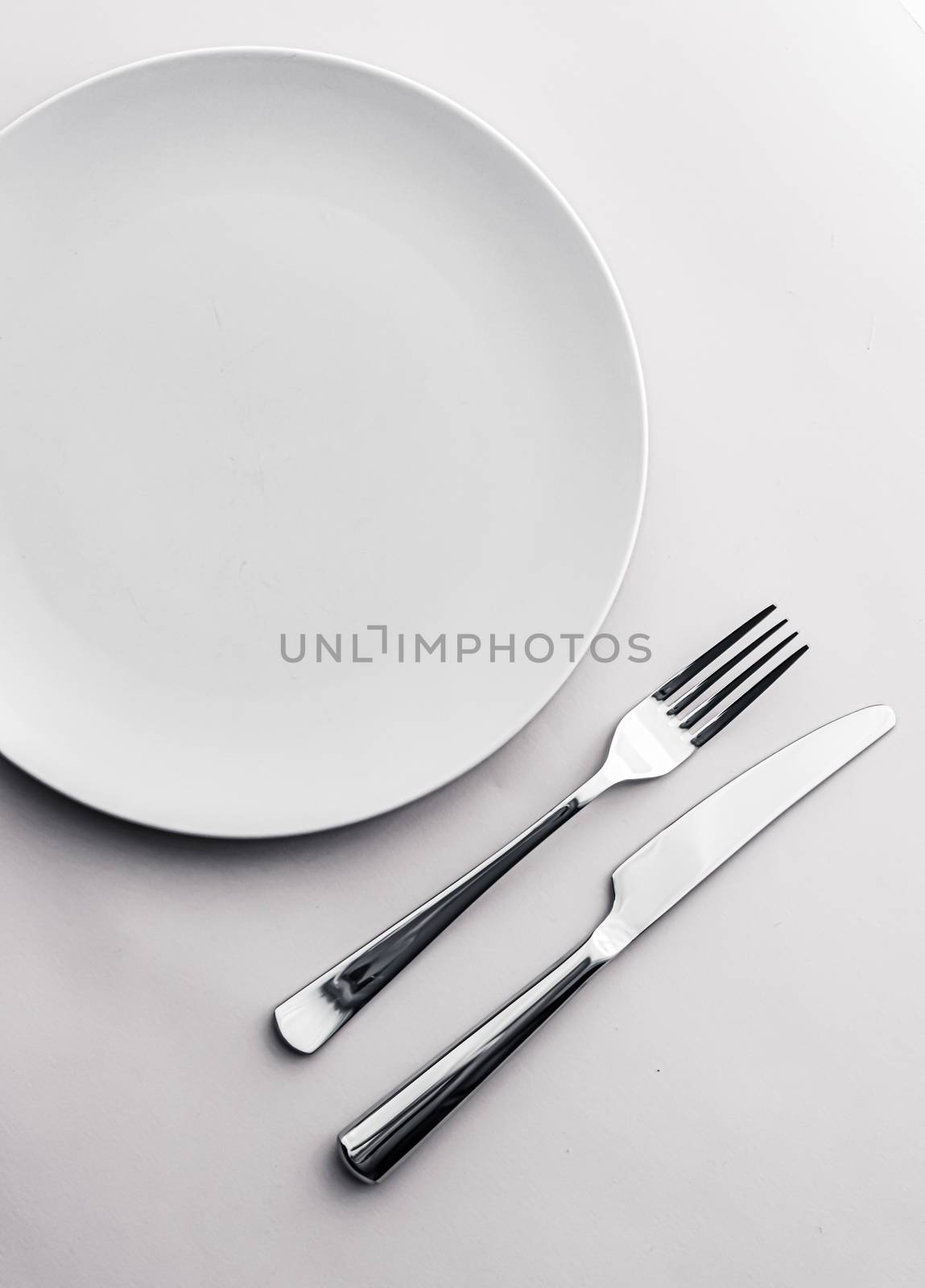 Empty plate and cutlery as mockup set on white background, top tableware for chef table decor and menu branding design